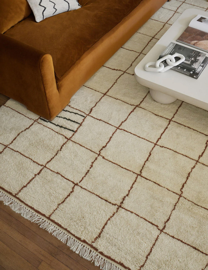 color::ivory #size::6--x-9- #size::8--x-10- #size::9--x-12- #size::10--x-14- #size::12--x-15- | Ivory and ochre Irregular Grid Rug by Sarah Sherman Samuel lays under a conganc velvet sofa and a rounded coffee table