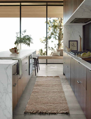 The Hagan rug in its runner size lays in a kitchen with stone countertops and floor to ceiling windows