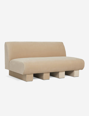 Angled view of the Lena armless brie beige velvet sofa
