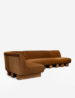 Angled view of the Lena left-facing cognac velvet sectional sofa with upholstered beam legs.
