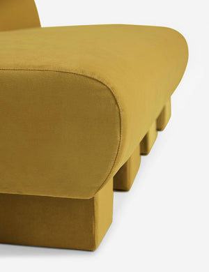 Close-up of the side of the Lena Goldenrod Velvet armless sofa