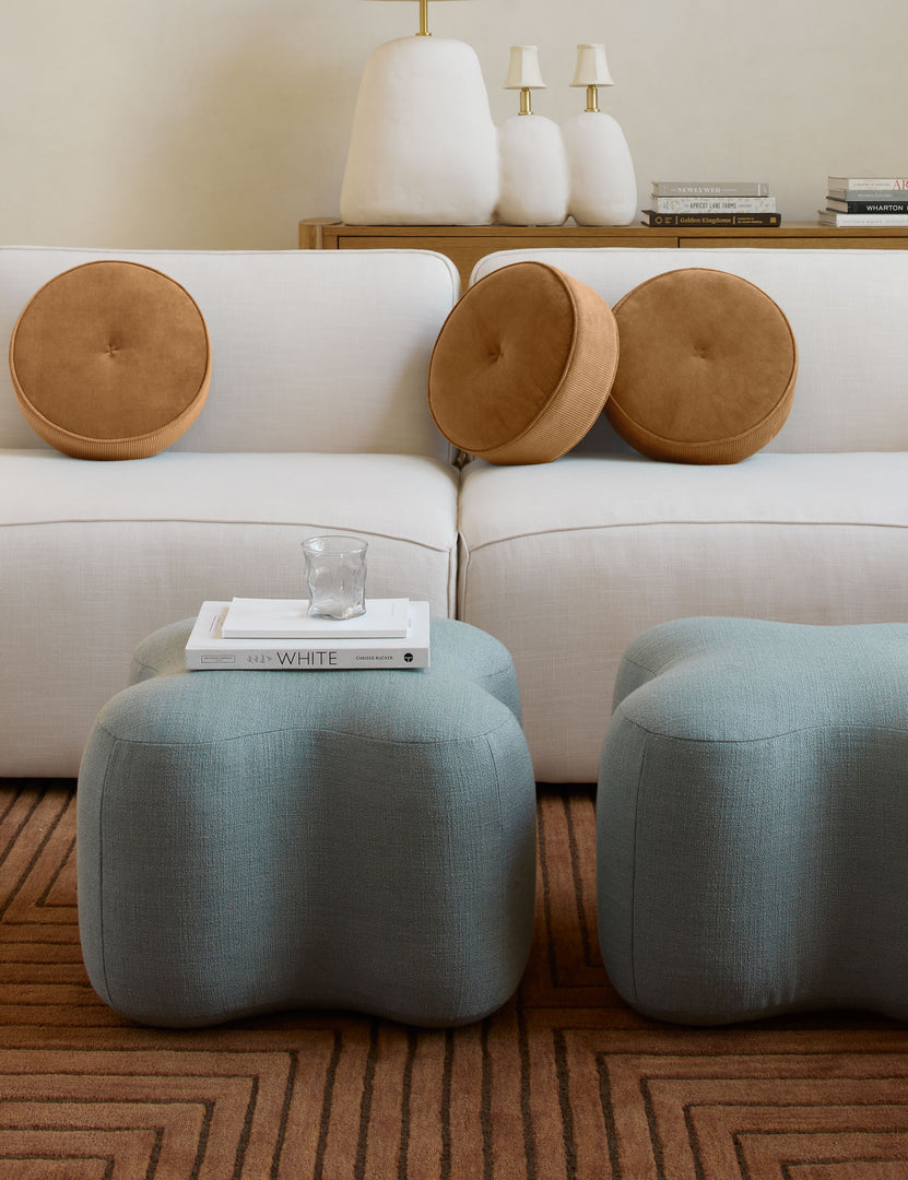 #color::amber | Three Velvet Disc amber Pillows by Sarah Sherman Samuel sit on a white linen sofa in a room with two blue linen ottomans