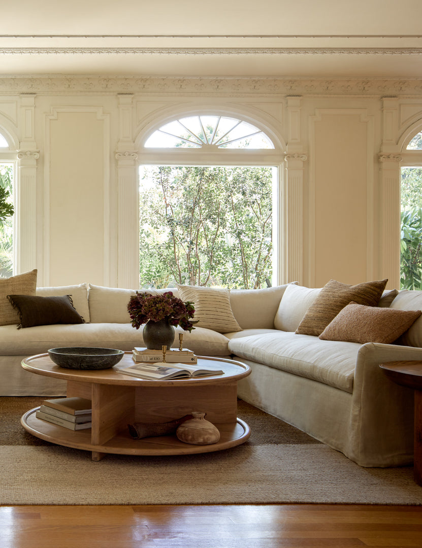 #color::natural #configuration::left-facing | The Portola Mushroom natural linen Slipcover corner sectional Sofa sits in a room with a round coffee table and accented walls