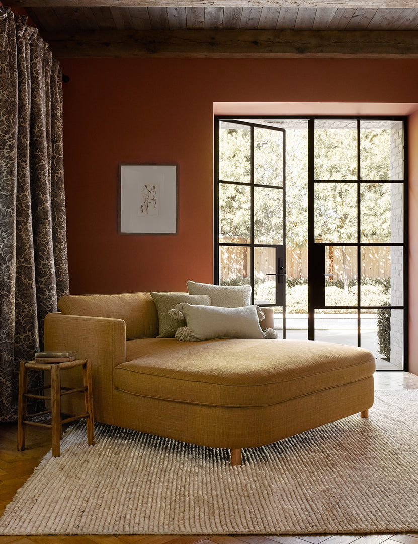 #size::6--x-9- #size::8--x-10- #size::9--x-12- #color::sand #size::10--x-14- | The Kenzi sand rugs lays in a terracotta room under a golden linen media lounger in front of black-framed french doors