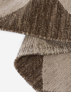 The Palau brown rug folded over itself