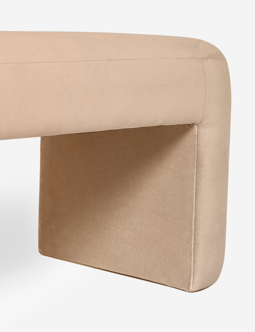 #color::buff | Close-up of the side and inner wall of the Mikhail light pink velvet foam-padded bench.