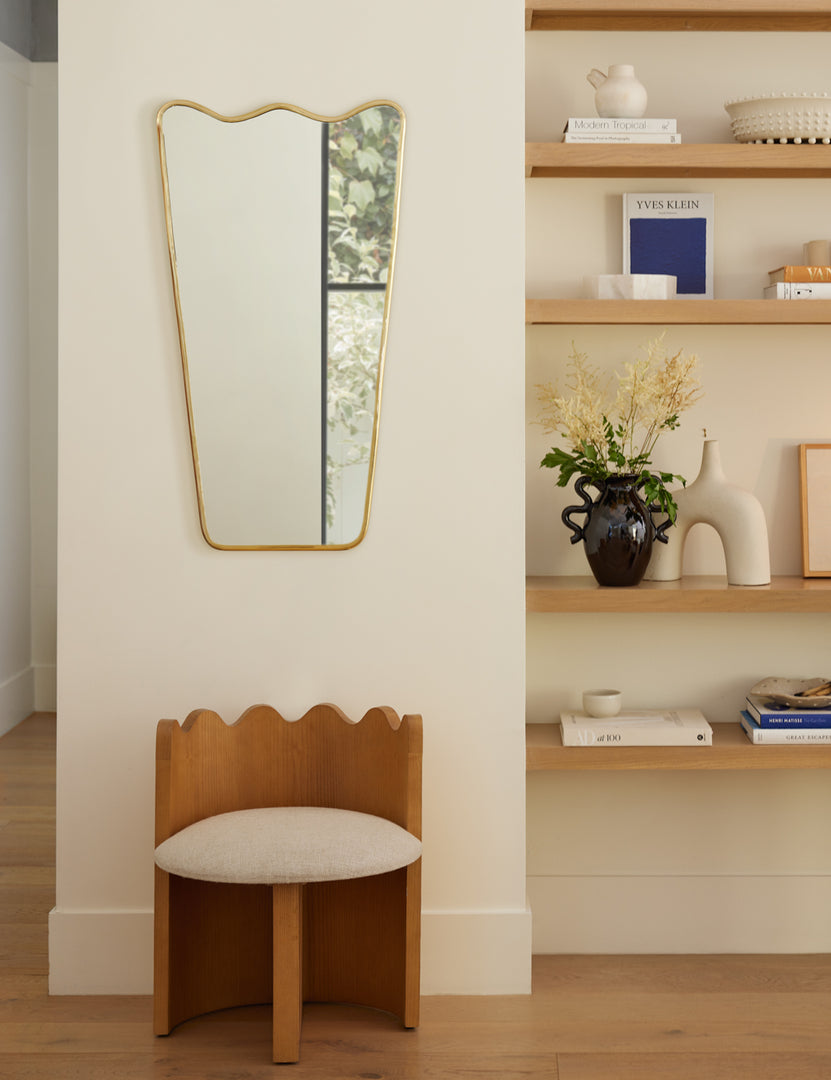 | Ripple Accent Chair sits under golden framed mirror to the left of a shelf adorned with decorative objects