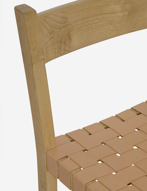 Close up view of the Vix light wood frame and woven leather seat dining chair.
