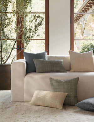 The victor throw pillow in multiple colorways and sizes sit together on a natural linen sofa in front of a wooden-framed window