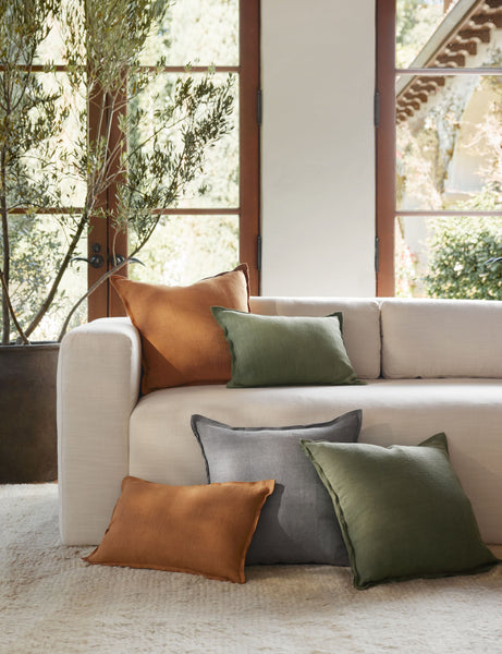 #color::dusty-blue #color::burnt-orange  #color::olive | The dusty blue, burnt orange, and olive arlo linen pillows sit together on a plush ivory rug and a natural linen sofa