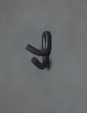 Black Leggy Crossed Wall Hook by SIN Ceramics hanging on a gray wall