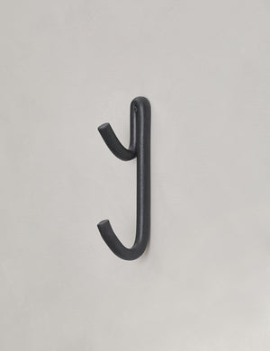 Black Leggy Long Wall Hook by SIN Ceramics hanging from a gray wall