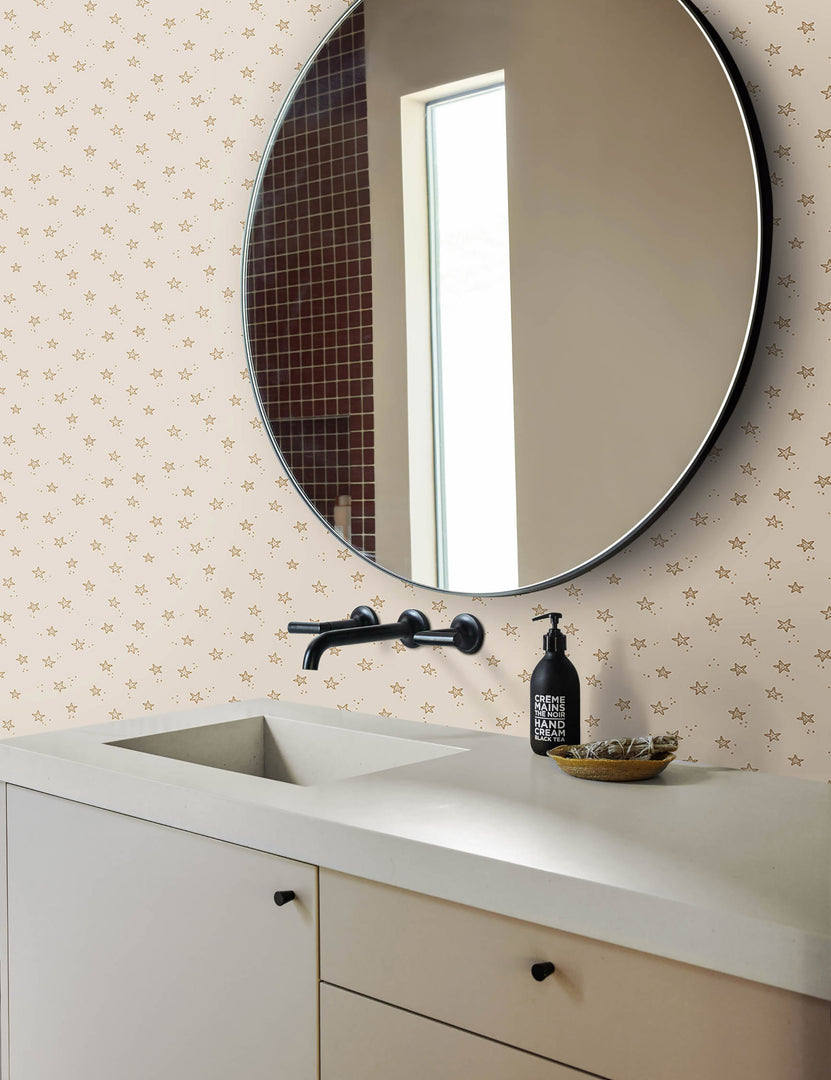 | The starfish wallpaper is in a bathroom with a white sink, black hardware, and a black framed round mirror