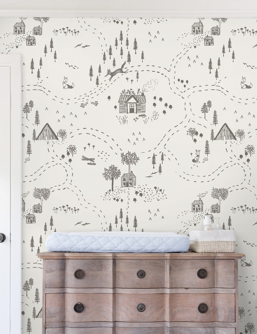 | The Through the Woods Wallpaper is in a room with a six drawer distressed wooden dresser with a changing station atop it
