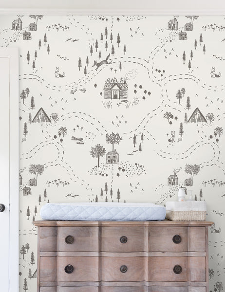 | The Through the Woods Wallpaper is in a room with a six drawer distressed wooden dresser with a changing station atop it