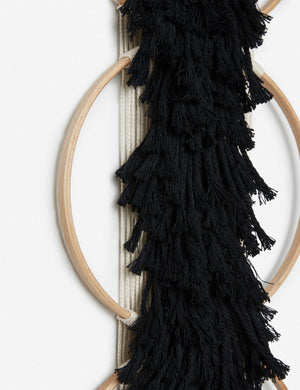Close-up of the tasseled material on the Studio Nom Lwazi black woven Wall Hanging by nom
