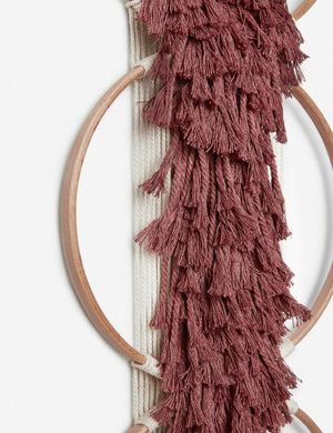 Close-up of the tasseled material on the Studio Nom Lwazi brick red woven Wall Hanging by nom