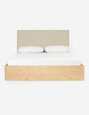 Nia bed with a wrap-around neutral wooden base and a natural linen rectangular headboard