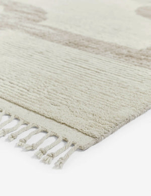 Close-up of the tasseled ends on the corner of the Nomad neutral-toned geometric floor rug with subtle ribbed design by Élan Byrd
