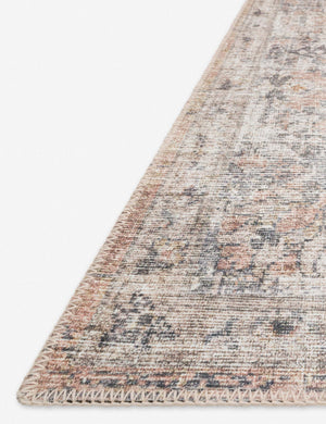 Angled close-up of the medallion patterns on the corner of the Roze blush and grey power-loomed rug