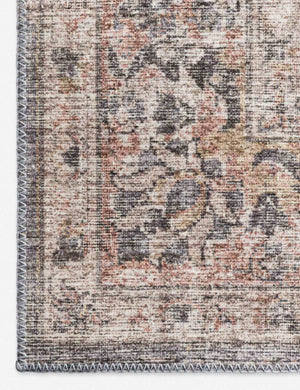 Close-up of the medallion patterns on the corner of the Roze grey and apricot power-loomed rug